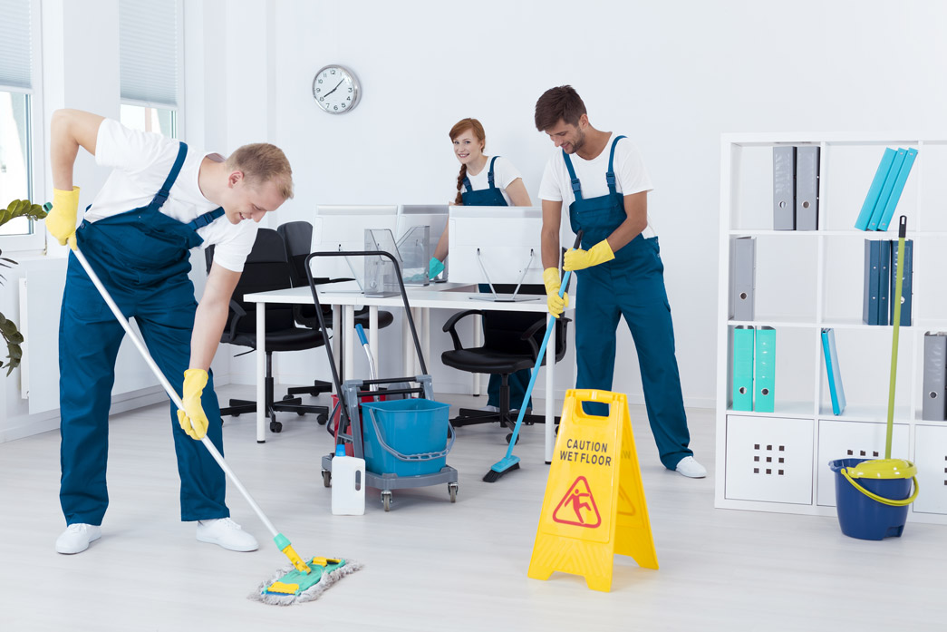 Young cleaners cleaning a modern office after deciding to start a franchise cleaning business.